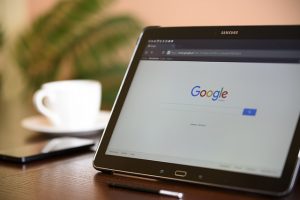 Tablet showing the Google search page beside a coffee cup
