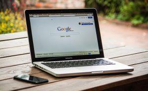 Laptop on an outdoor table displaying the Google homepage