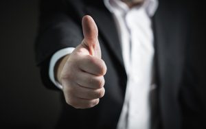 Man in a suit making a thumbs-up gesture