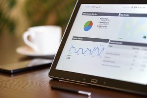 Tablet showing an analytics dashboard beside a coffee cup