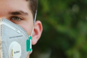Young man outdoors wearing a respirator face mask