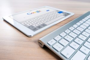 Tablet displaying Google search beside a desktop keyboard
