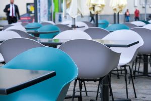 Rows of empty tables and chairs at an outdoor cafe