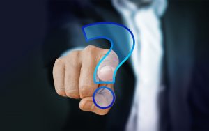 Hand touching a glowing blue question mark