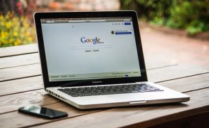 Laptop on an outdoor table displaying the Google homepage
