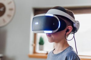 Boy in profile wearing a white virtual reality headset indoors