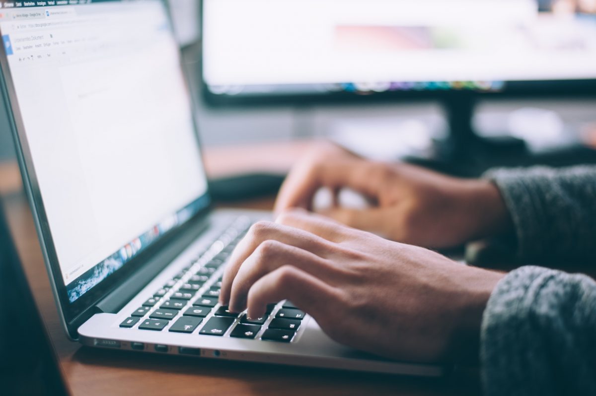 man writing on macbook